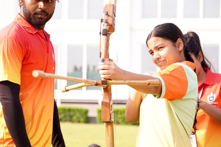 A student practising archery with her instructor