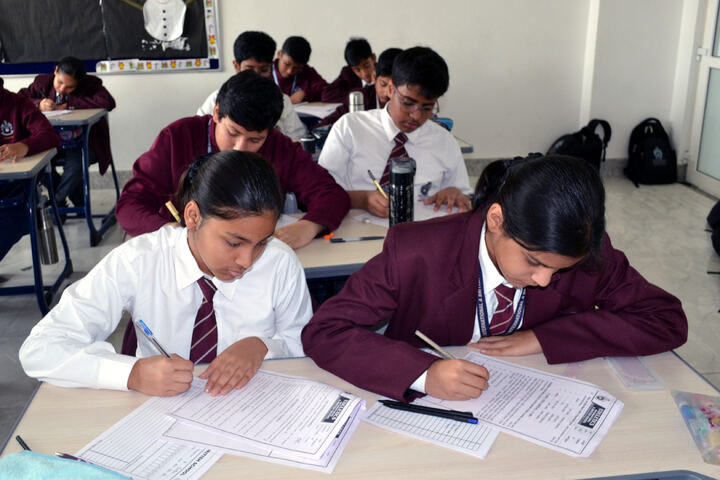 Students in school uniform concentrating on their papers during a final term examination