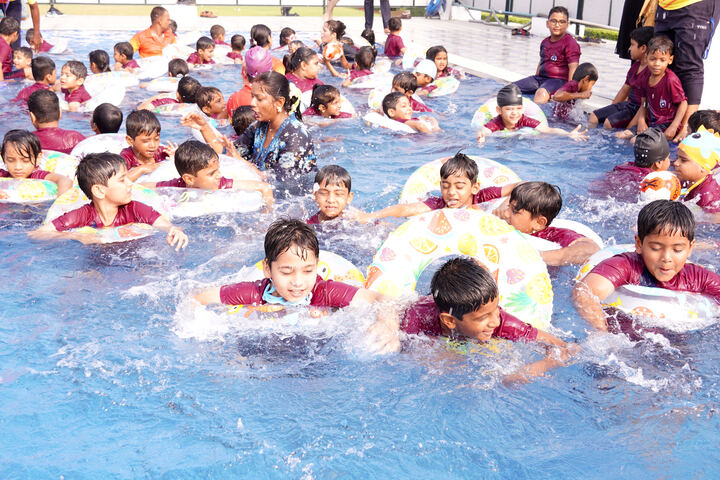 Students enjoying a swimming session in the school pool during the summer camp